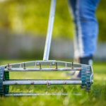Grass aerator on the green lawn